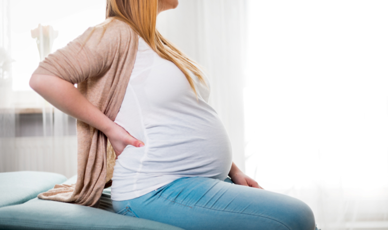 Une femme enceinte assisse pour aborder la physiologie de la grossesse